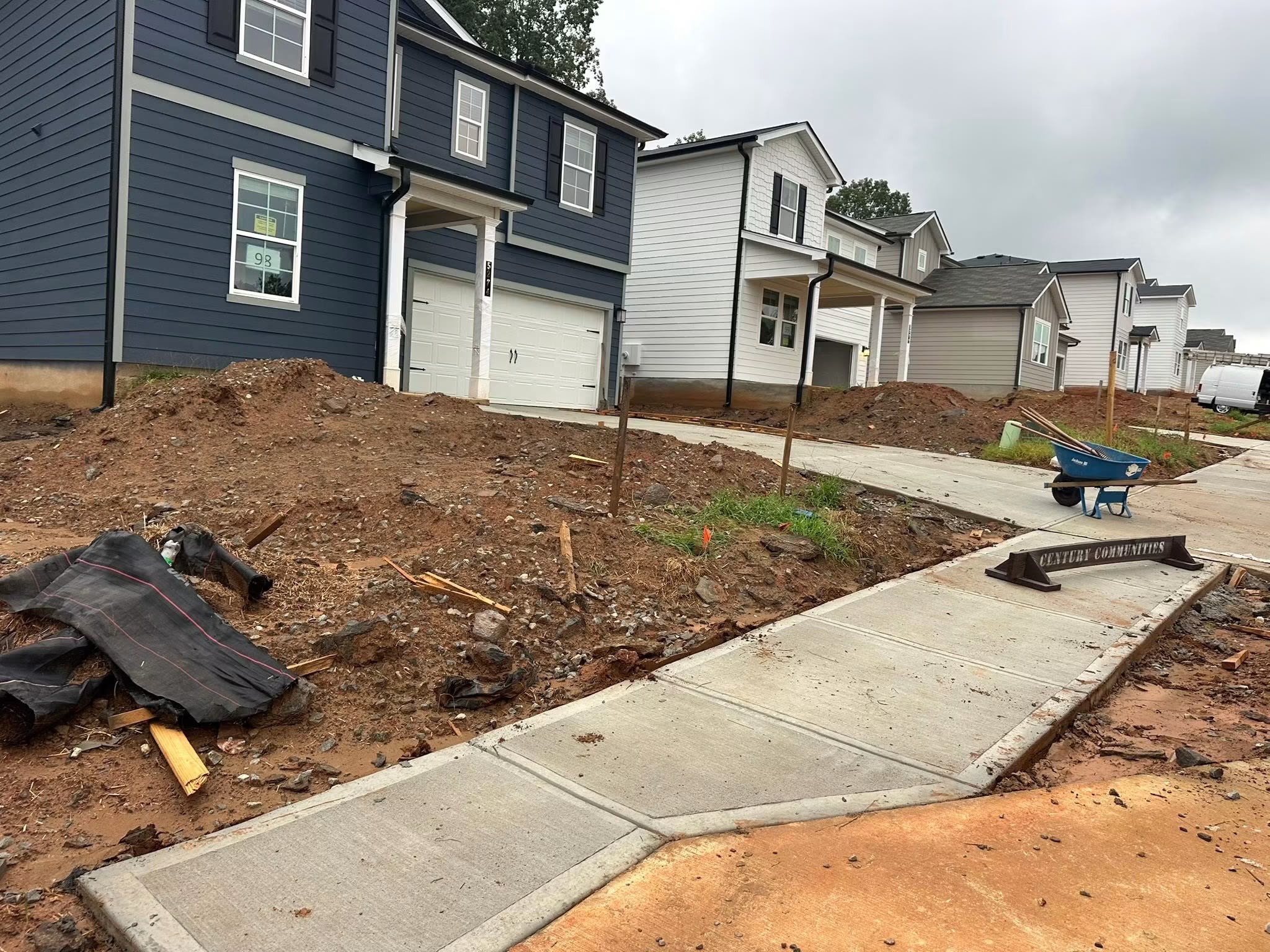 Before: steep unfinished clay slope with construction debris