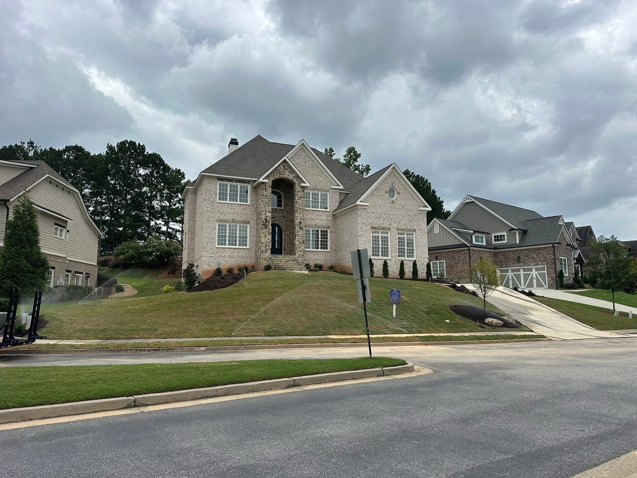 After: luxury finished lawn with fresh sod, mulch beds, foundation plantings, and active irrigation