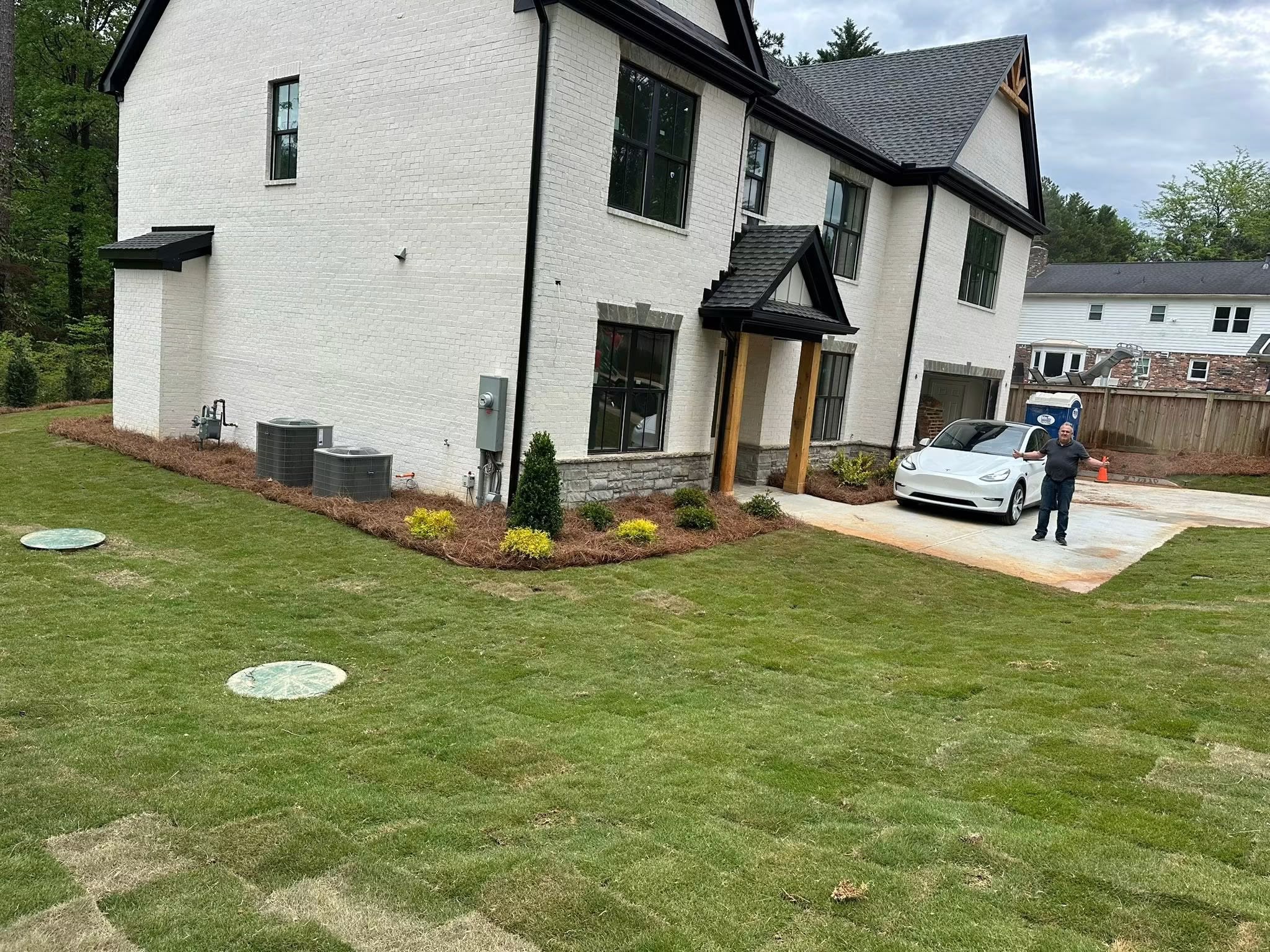 After: pristine sod lawn, pine straw beds, and decorative evergreen shrubs