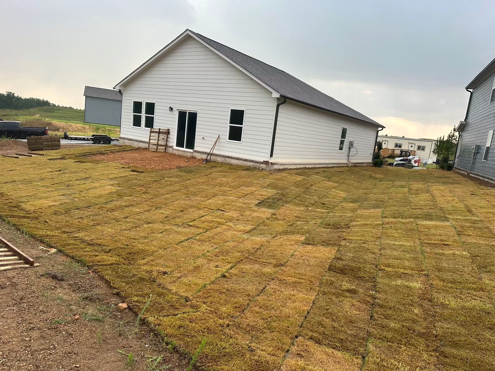 After: expansive, uniform green sod lawn covering the entire backyard property