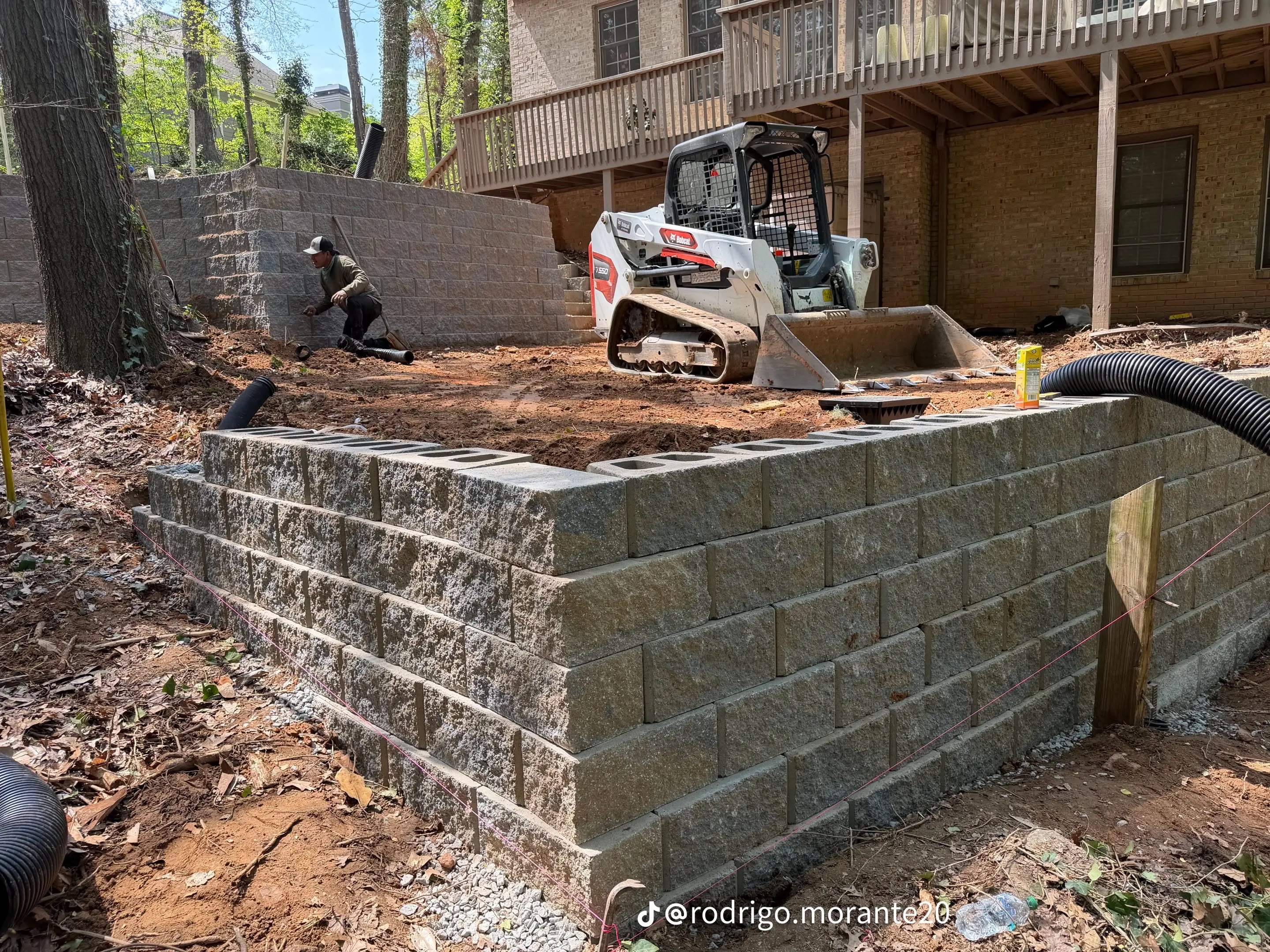 GGM crew building a retaining wall with a Bobcat skid-steer on a Metro Atlanta job site